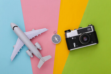Compass, camera and air plane on colored background. Travel, adventure flat lay. Top view