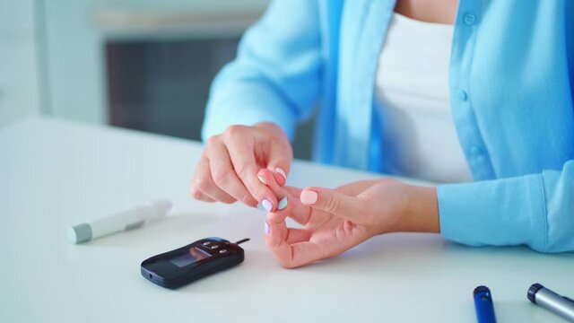 Diabetics patient using glucose meter for measurement and checking blood glucose level at home. Diabetes control