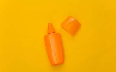 Sunblock bottle on a yellow background. Skin protection. Beach vacation. Top view