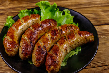 Tasty grilled sausages on a wooden table