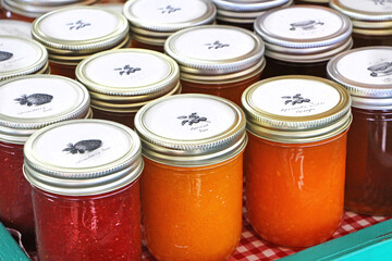 Farm market - fresh products - various jam flavors (strawbery, apricot, blackberry) jars with white lids.