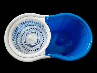 Blue mop bucket isolated on black background. Top view of mopping tub containing spinner.