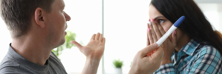 Man spreads hands front girl with pregnancy test. People get nervous when they learn about desired pregnancy. Couple did not think and was in state extreme shock. Reason for urgent medical attention