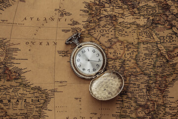 Antique pocket watch on an old map