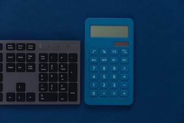 PC keyboard with calculator on a classic blue background. Top view