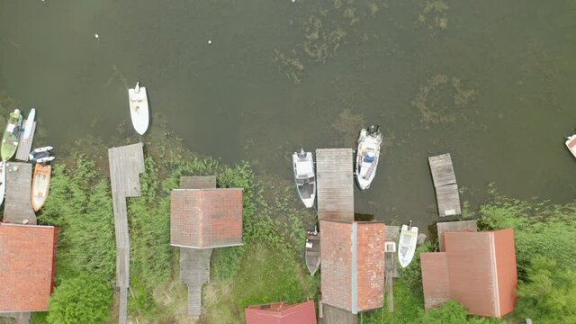 Aerial top down view of boathouses along shoreline in the archipelago, pan right movement