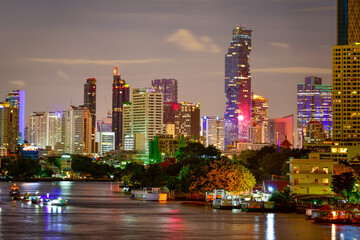 Fototapeta na wymiar Bangkok City modern office buildings, condominium, hotel with Chao Phraya River during sunset sky in the capital of Thailand