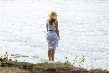 girl in a white dress alone by the sea. kind of shadi.