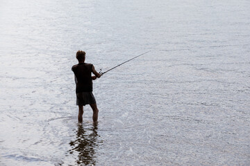  A man fishing from a shallow water