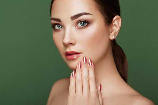 Beauty Brunette Woman With Perfect Makeup. Glamour Girl. Red Lips And Nails. Perfect Eyebrows. Skin Care Foundation. Beauty Girls Face Isolated On Green Background. Fashion Photo