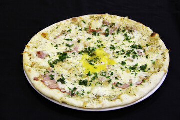  Meat pizza with cheese, egg, and dill on a white plate