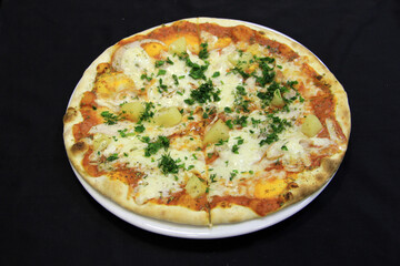 Pizza with pineapple, cheese and dill on a white plate