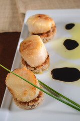 French food Flambeed Scallop on white plate