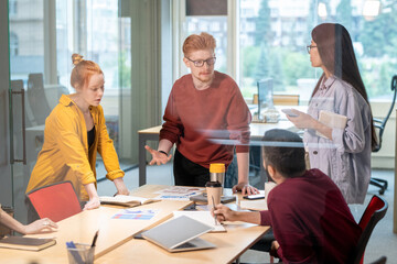 Group of young confident intercultural brokers discussing business strategies