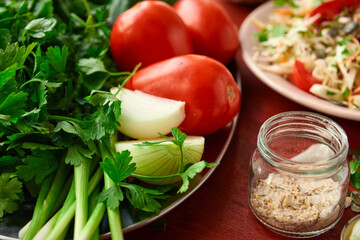 healthy food - fresh chopped vegetables on a wooden background, tomatoes and greens
