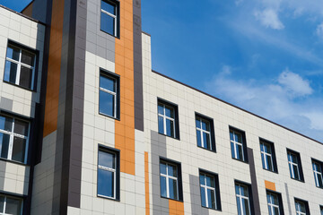 facade of a modern building on a bright Sunny day, siding and Windows, beautiful exterior of the new building