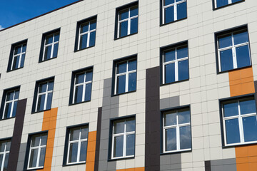facade of a modern building on a bright Sunny day, siding and Windows, beautiful exterior of the new building