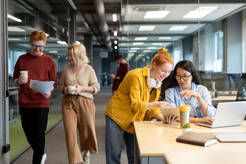 Two young intercultural businesswomen consulting about point of presentation