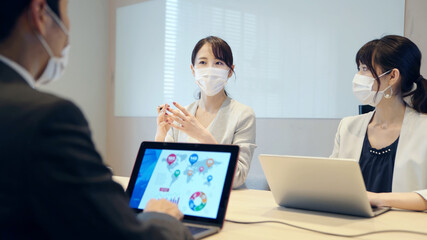 マスクをつけてミーティングする人々　感染対策　新しい生活様式