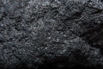 Fototapeta na wymiar Blurred black background in soft focus with hard coal at high magnification