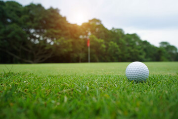Blurred golf ball on green in the evening golf course with sunshine in thailand