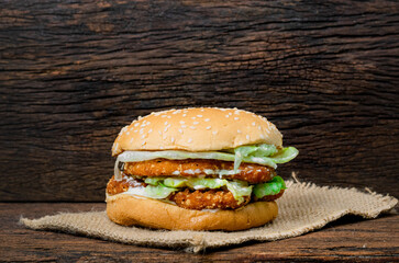 Hamburger a chicken on a wooden background