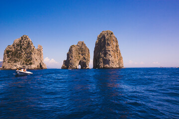 Sunny day in the sea outside the coast of Capri, view of the faraglioni.