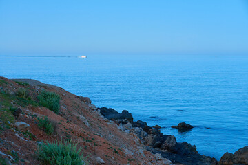 Stones on the Sea coast on Crete, Greece on sunlight close up with foggy horizon on Mediterranean Sea on a background. Copy space.