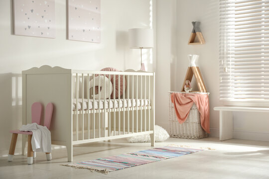 Cute baby room interior with crib and decor elements