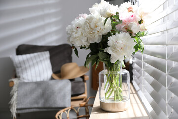 Bouquet of beautiful peony flowers on window sill indoors. Space for text