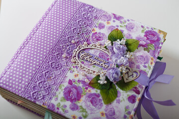 Fabric covered weddig scrapbook album with purple lace, flowers and inscription in Russian reads - Our Wedding.
