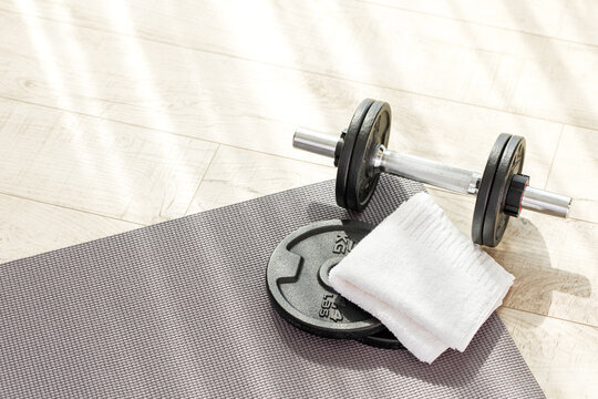 top view iron dumbbells and towel on floor. fitness at home.