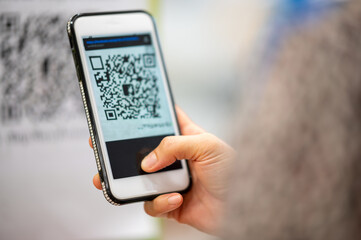 women using a mobile phone to scan a pr code for payment