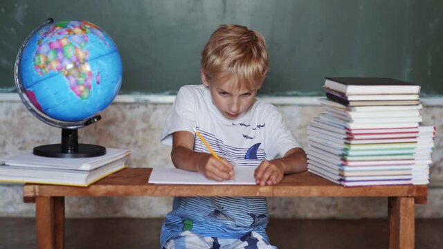 A boy of eight years old is working on a geography lesson at home.