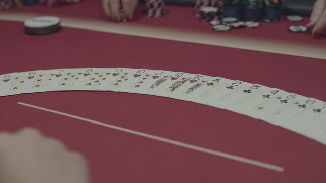 The hand laying out the pocker cards on table during game