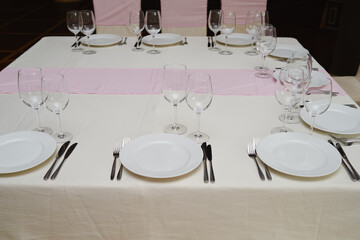 Table set with blank guest card, plate with white napkin and cutlery on table, copy space. Place setting at wedding reception. Table served for wedding banquet in restaurant