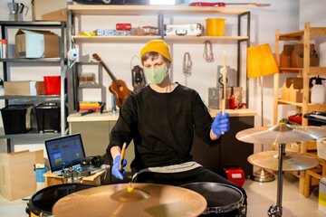 Contemporary young man in protective gloves and mask making new music