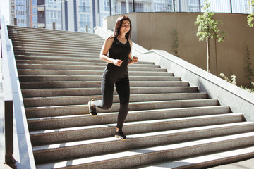 Obraz premium Street fitness, cardio workout, sport in the city. Young fit woman exercising on the stairs. Endurance and healthy lifestyle