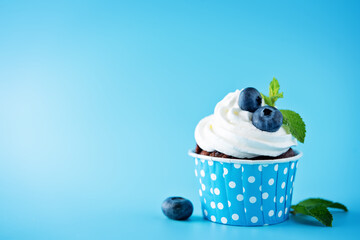 Chocolate cream cheese cupcakes with whipped cream, mint leaves and blueberry