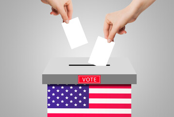 US Elections Concept : Hand holding and putting voting paper in ballot voting box with USA flag symbol.