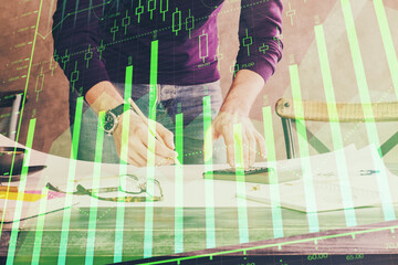 Multi exposure of man standing and planing investment with stock market forex chart.