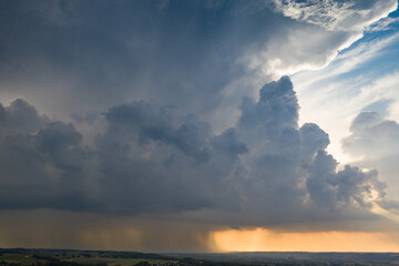 Gewitterwolke mit Regenschauer bei Sonnenuntergang