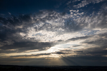 Fototapeta na wymiar Sonnenstrahlen durchbrechen Wolken an einem bewölkten Abendhimmel