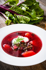 Borsch - beetroots soup with cream on wooden table

