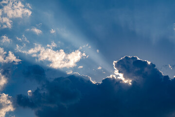 Fototapeta na wymiar Sonnenstrahlen leuchten hinter dunkler Wolke hervor
