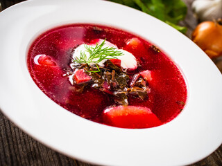 Borsch - beetroots soup with cream on wooden table
