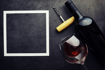 Wine glass and black wine bottle. Nuts cheese and tomatoes for snack.