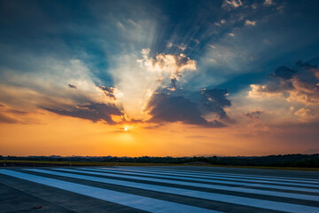 Runway, airstrip in the airport terminal with marking in sunset background. Travel aviation concept.