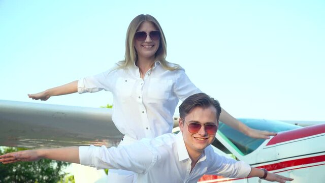 Happy couple in front of the parked small airplane plane. The concept of happiness, honeymoon