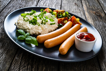Breakfast - cottage cheese, boiled sausages and vegetables served on wooden table